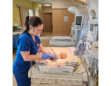 Nurse working in NICU with a fake baby.